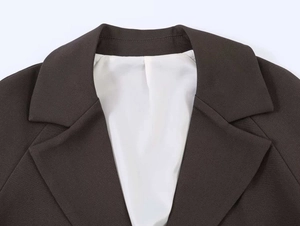 Detail of notch lapel and white lining on coffee brown blazer with woven texture