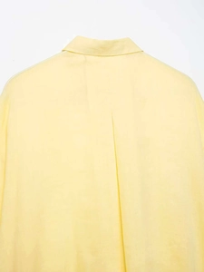 Detail view of light yellow shirt back featuring a classic collar and center box pleat
