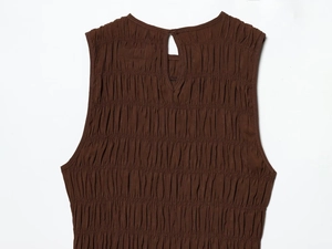 Detail of dark brown sleeveless dress with smocked fabric and back button closure
