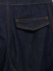 Close-up of dark blue denim jacket pocket with orange contrast stitching details