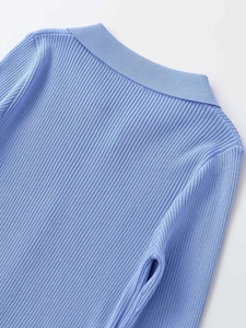 Detail of light blue ribbed knit fabric showing collar and shoulder texture quality