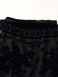Detailaufnahme des schwarzen Burnout-Samt-Blumenmusters auf dem Vintage-Midirock-Stoff