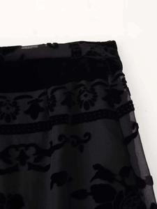 Detail von schwarzem Netzgewebe mit floraler Beflockung und Samtbesatz-Verzierung