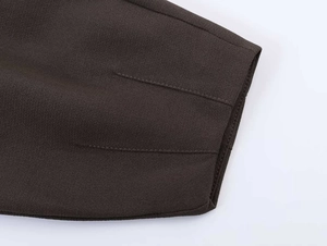 Detail of dark brown blazer fabric featuring precise double stitching and woven texture