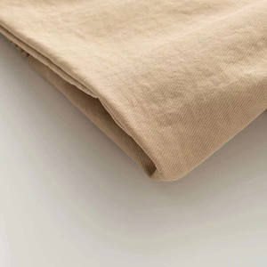 Detailed close-up of khaki twill fabric texture showcasing thickness and weave quality