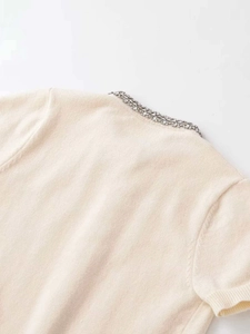 Close-up of beige knit cardigan featuring exquisite rhinestone embellishments on neck