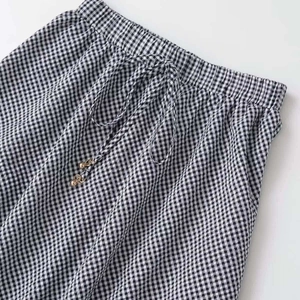 Black and white gingham skirt featuring an elastic waist and drawstring with gold beads