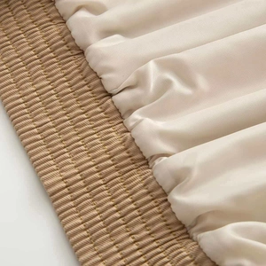 Detail of cream satin fabric with ruched texture and khaki quilted elastic waistband