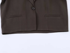 Detail view of the single-button closure and welt pockets on this coffee brown blazer
