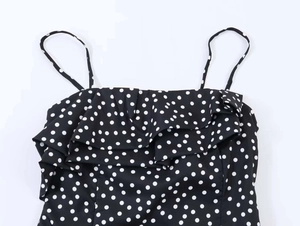 Détail de l'encolure à volants et du motif à pois sur la robe d'été noire à bretelles
