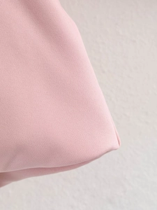 Close-up of durable pink canvas fabric with detailed reinforced stitching on the corners