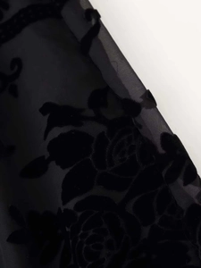 Makroaufnahme von schwarzem Ausbrenner-Stoff mit Rosen-Flockmuster und Spitze