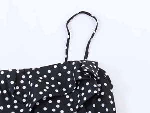 Détail de la robe noire à pois blancs avec volants délicats et de fines bretelles spaghetti