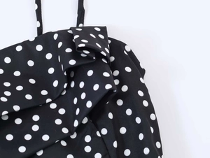 Détail d'une robe à pois avec des bords à volants et de fines bretelles noires