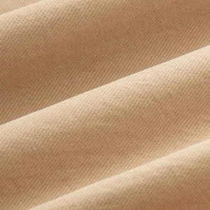 Close-up of khaki corduroy fabric showing vertical ribbed texture and soft material