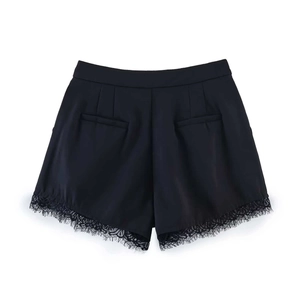Detail view of high waisted black shorts featuring elegant lace trim on the hem