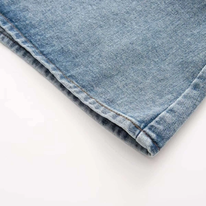 Detail shot of light blue denim fabric with orange stitching on a V-neck dress