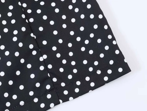 Vue détaillée du tissu à pois et des coutures soignées sur une robe d'été vintage noire