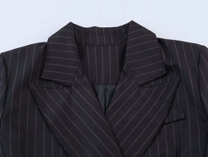 Close-up of classic peak lapel and white pinstripe texture on black blazer fabric