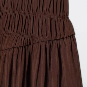 Elegant dark brown sleeveless midi dress featuring detailed smocking and layered texture