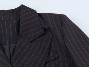 Detail of classic notched lapel and pinstripe pattern on a black tailored blazer