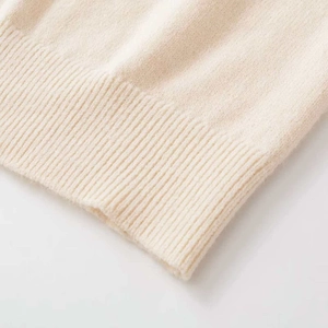 Minimalist beige knit cardigan with soft texture and refined ribbed cuffs detail
