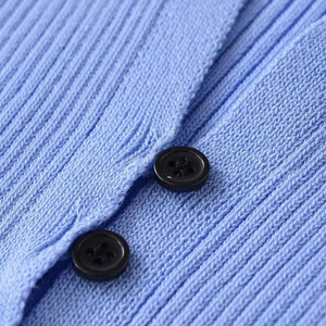 Close-up of light blue ribbed knit cardigan with elegant black button details