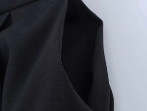 Detail shot of black woven fabric showing slanted pocket design and fine twill texture