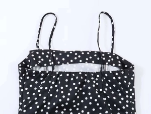 Détail d'une robe vintage à pois noirs avec fines bretelles et encolure élastique