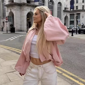 Pink oversized pilot bomber jacket with balloon sleeves on a city street outfit