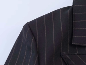 Detail of premium pinstripe texture and fine stitching on a black tailored blazer