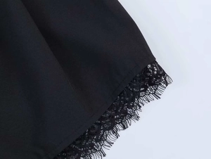 Detailed close-up of delicate black eyelash lace trim and smooth fabric stitching