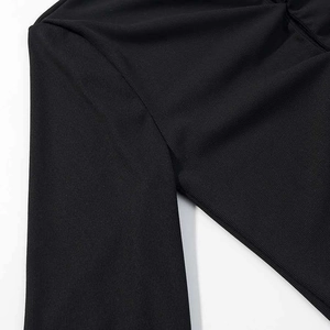 Close-up of black ribbed fabric showing detailed vertical stripe texture and stitching