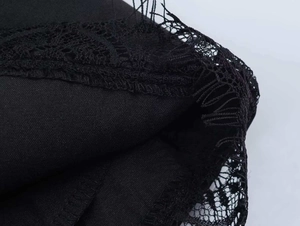 Close-up of black blazer fabric featuring delicate eyelash lace trim and fine mesh details