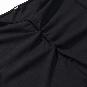 Close-up of black ribbed fabric dress neckline with subtle gathered pleat detail