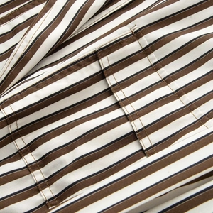 Détail macro du tissu rayé et coutures de précision sur la poche de la veste décontractée