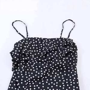 Haut rétro noir à pois avec volants et coupe ajustée pour un style élégant