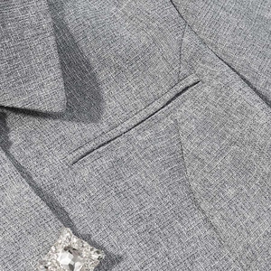 Detailed macro view of gray blazer fabric with a luxurious square rhinestone button