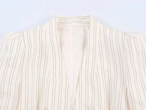 Close-up of V-neck striped blazer showing shoulder pleats and breathable fabric texture
