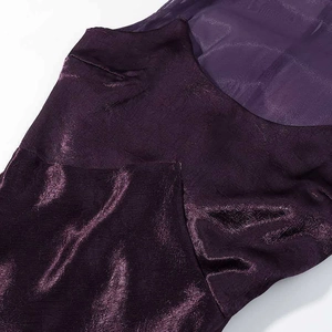 Detail of dark purple gown featuring rippled satin fabric and sheer mesh patchwork