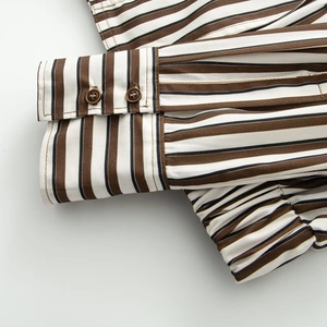 Détail de poignets de veste à rayures avec deux boutons et finition élastique serrée