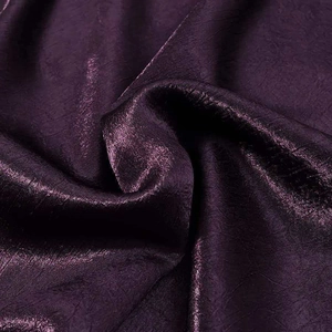 Close-up of deep purple glossy satin fabric with elegant crinkle texture and metallic sheen