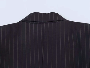 Close-up detail of pinstripe pattern and collar stitching on a black business blazer