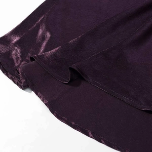 Detail of dark plum satin fabric with glossy texture and fine pleated workmanship