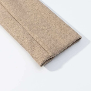 Detailed macro view of premium oatmeal wool blend fabric showing neat stitching on sleeve