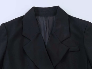 Detailed close-up of notched lapels and textured black fabric on a formal blazer jacket