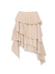 Detail view of champagne ruffled skirt featuring layered chiffon and asymmetric hemline