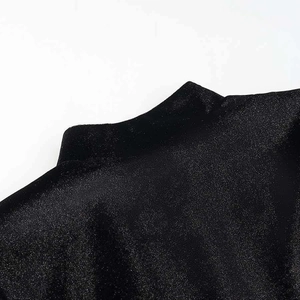 Dettaglio del top nero a lupetto in tessuto scintillante con cuciture di precisione