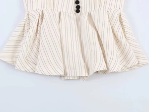 Detail of striped waist design with decorative black buttons and pleated peplum hem
