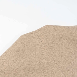 Close-up of thick light brown wool texture with detailed vertical stitching seam